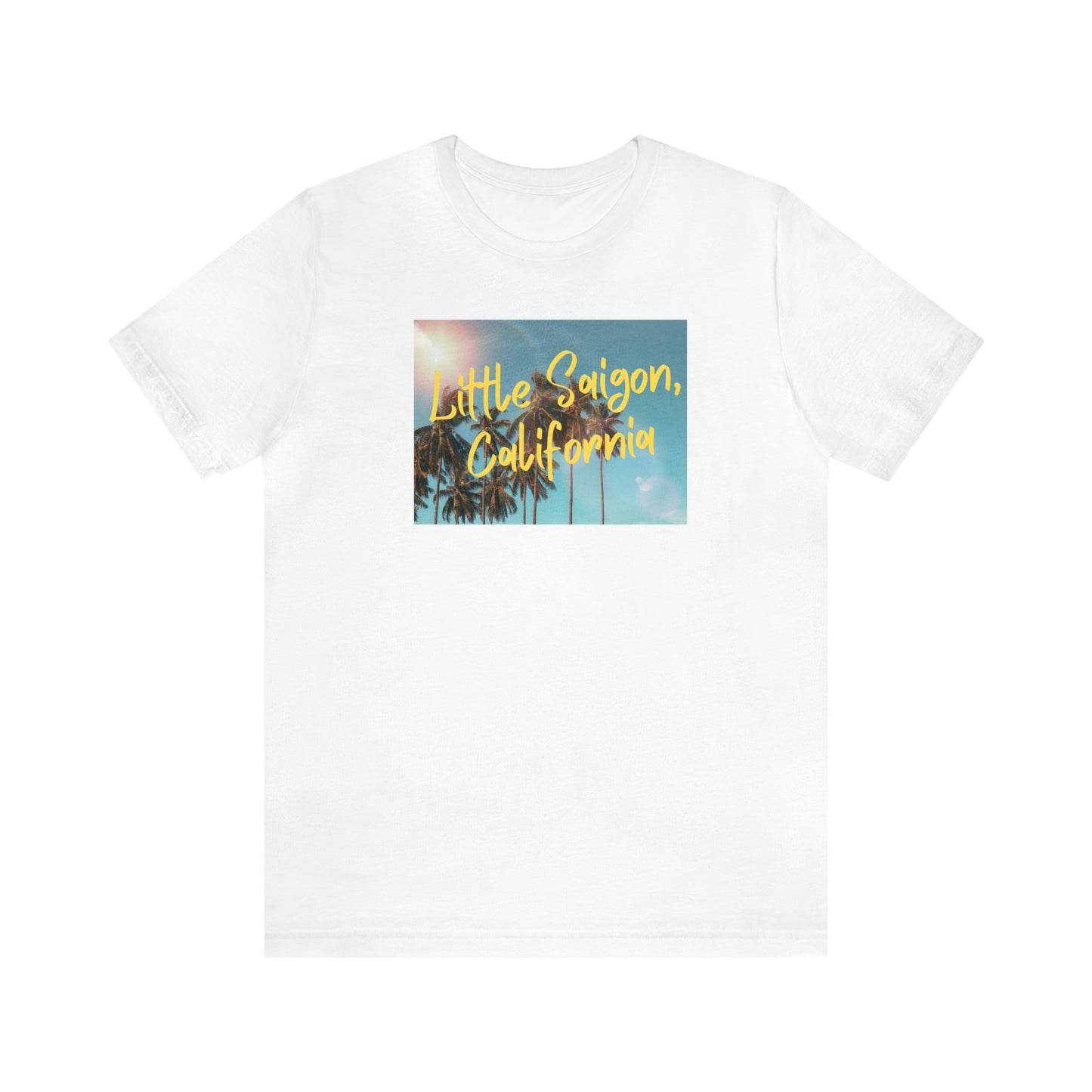 White t-shirt with square picture of a shining sun, palm trees, and blue sky with words Little Saigon, California written in yellow letters across the picture. Front view