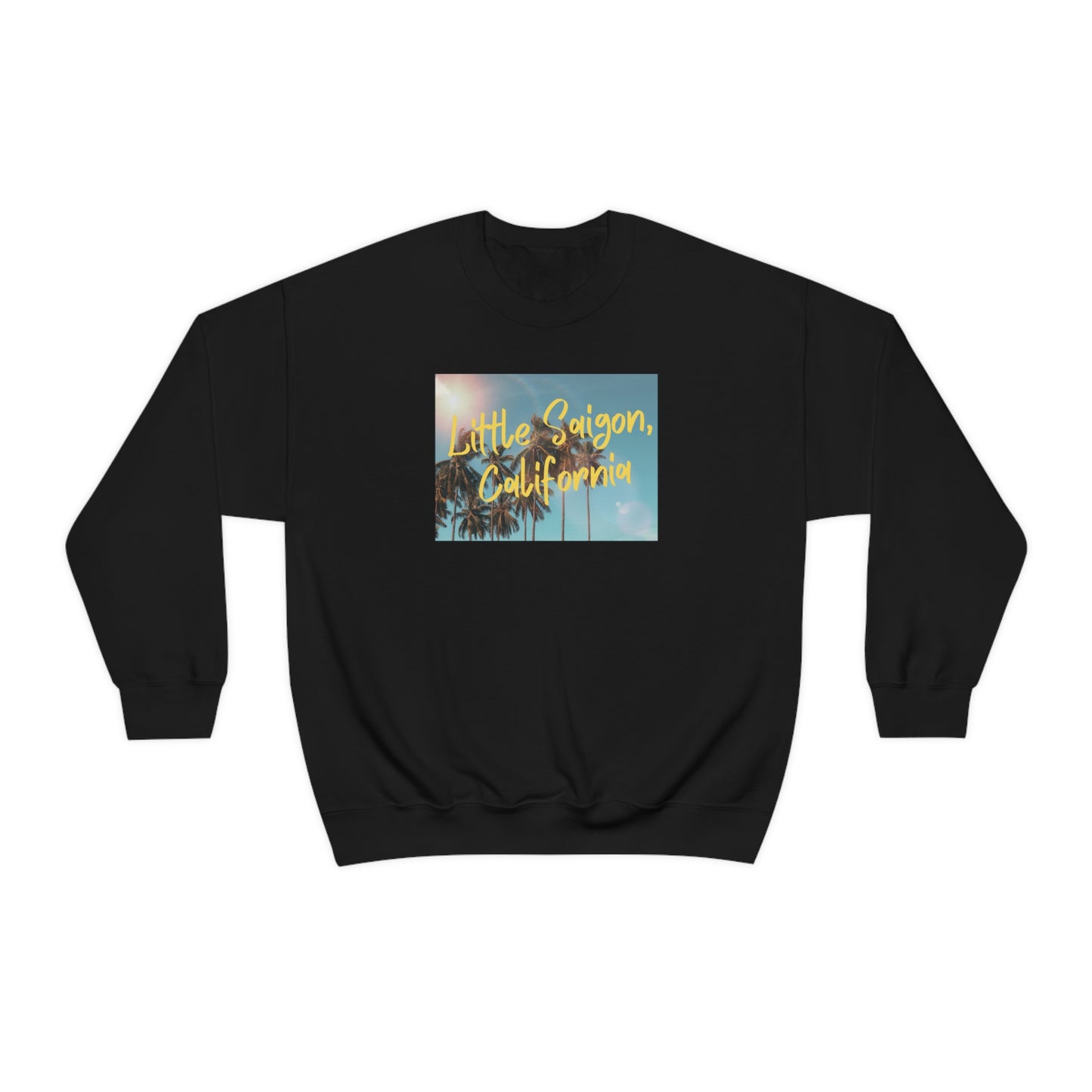 Black sweater with square picture of a shining sun, palm trees, and blue sky with words Little Saigon, California written in yellow letters across the picture. Front view