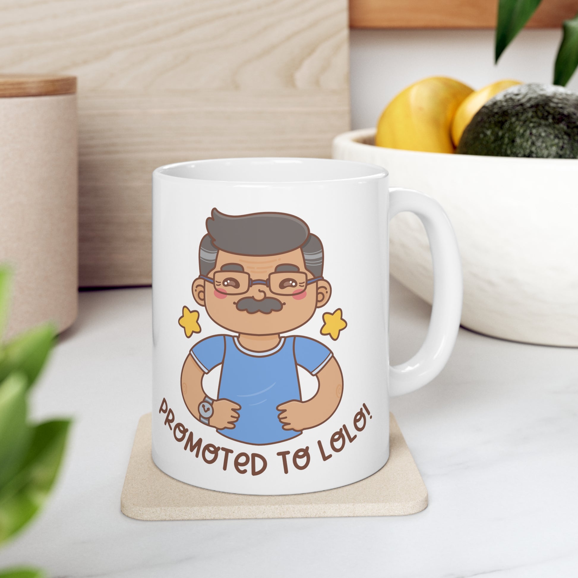 White mug with a kawaii picture of an old man with a mustache wearing glasses. A caption below the picture reads Promoted to Lolo! Front view