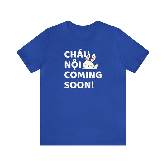 Blue shirt with four rows of words reading Chau Noi Coming Soon! in white letters. White rabbit winking.