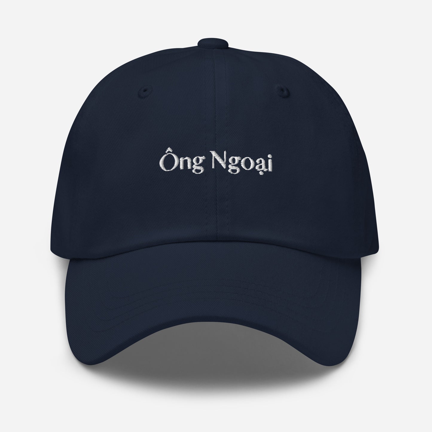 Navy blue dad hat with words Ong Ngoai in white stitching in the middle of the front of the hat. Front View